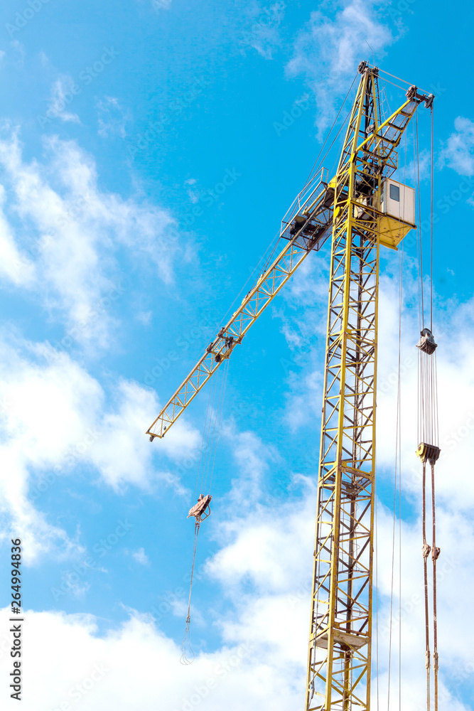 Industrial background with construction crane over blue cloudy sky