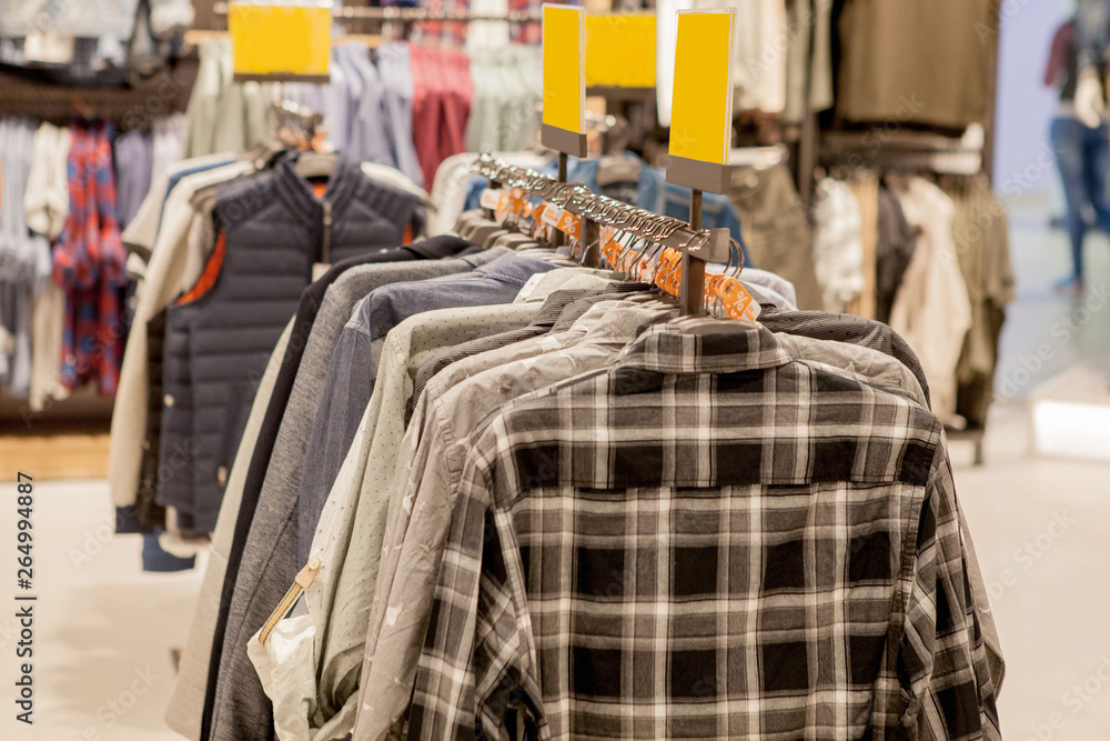 Clothes hang on a shelf . Cloth Hangers with Shirts. Men's stylish clothes. Fashion and trade concept