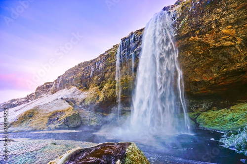 View of Seljalandsfoss waterfall at dawn in winter in Iceland.