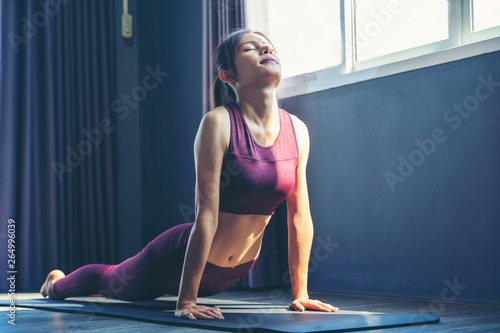 Portrait of gorgeous young woman practicing yoga indoor. Concept of healthy life and natural balance between body and mental developmen