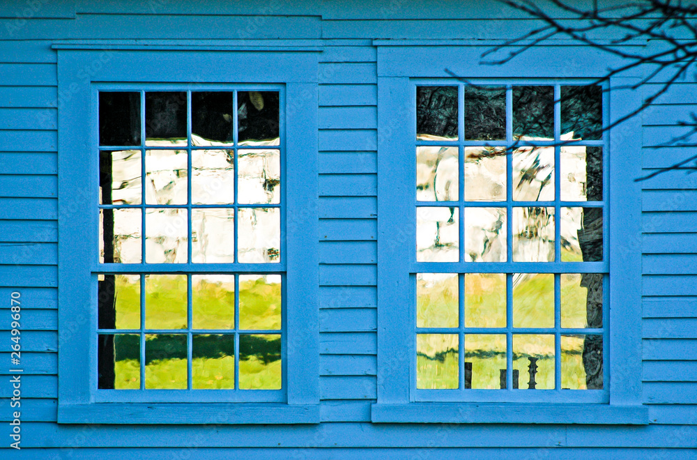 Obraz premium two windows on a blue building reflecting