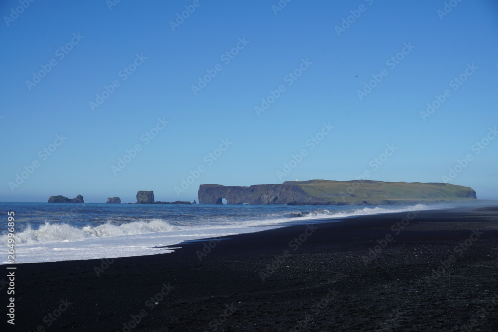 Breathtaking Reynisfjara beach with rocks and blue sky on Iceland in summer