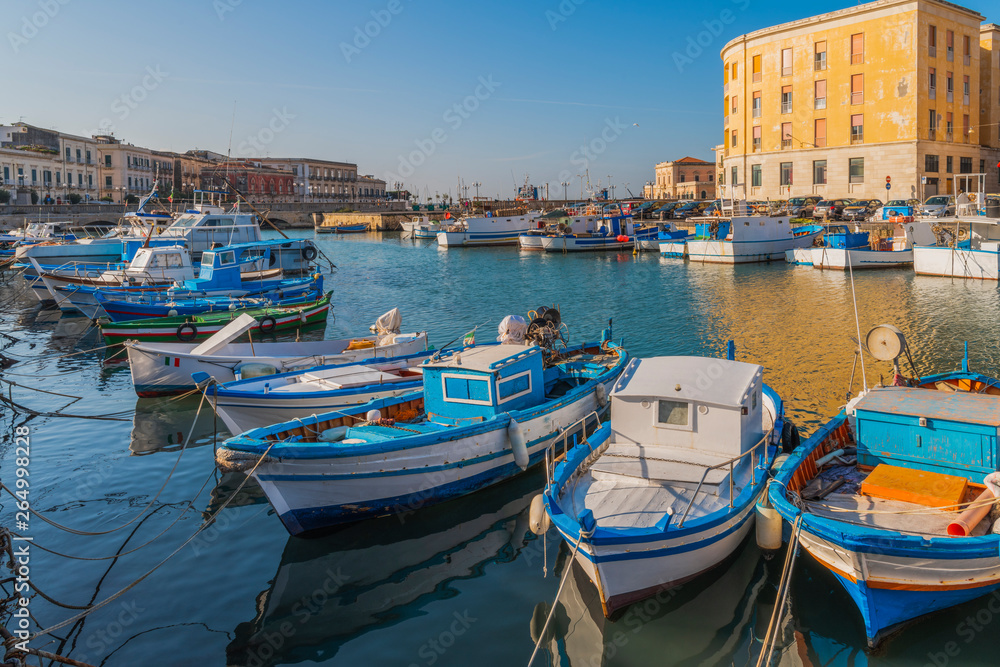 Fishing boats on water in the bay of Ortigia island in Syracuse, Sicily, south Italy 