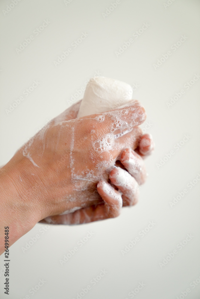 close up of woman washing her hands with a bar of soap and soapy suds close up of woman washing her hands with a bar of soap and soapy suds