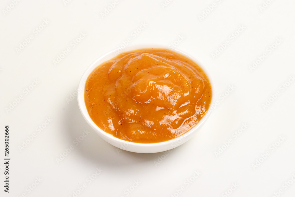 Orange sauce in white plate on white background. Orange sauce in white plate on white background.