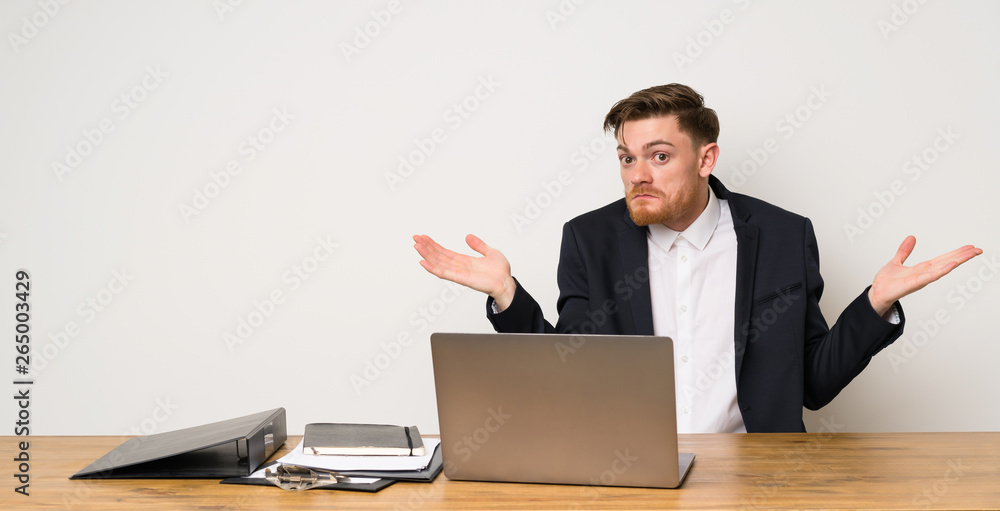 Businessman in a office making doubts gesture Businessman in a office making doubts gesture