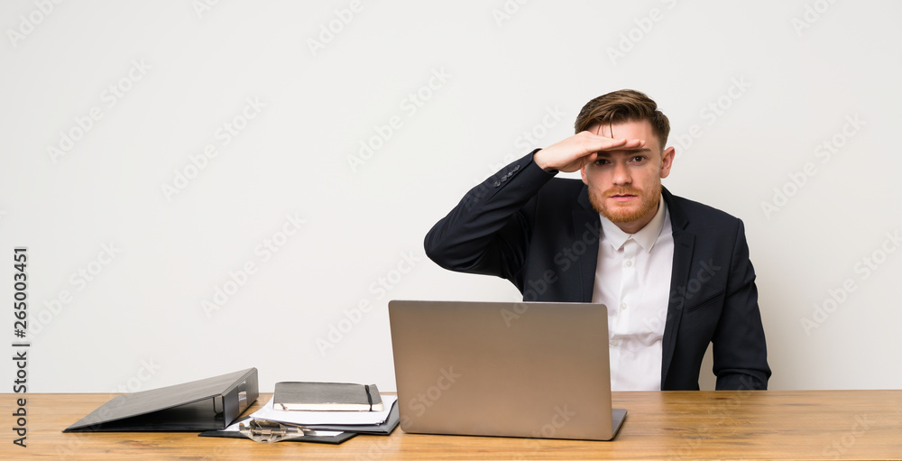 Businessman in a office looking far away with hand to look something Businessman in a office looking far away with hand to look something