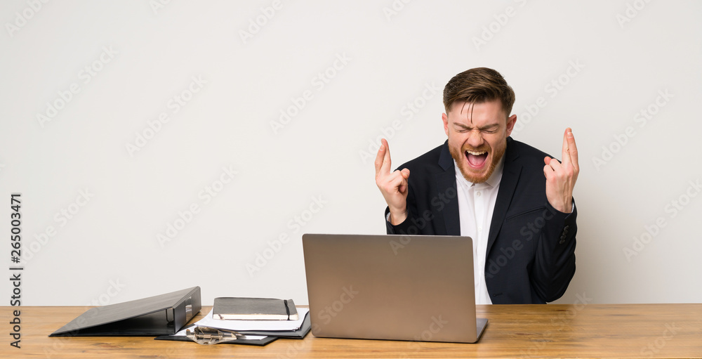 Businessman in a office with fingers crossing Businessman in a office with fingers crossing