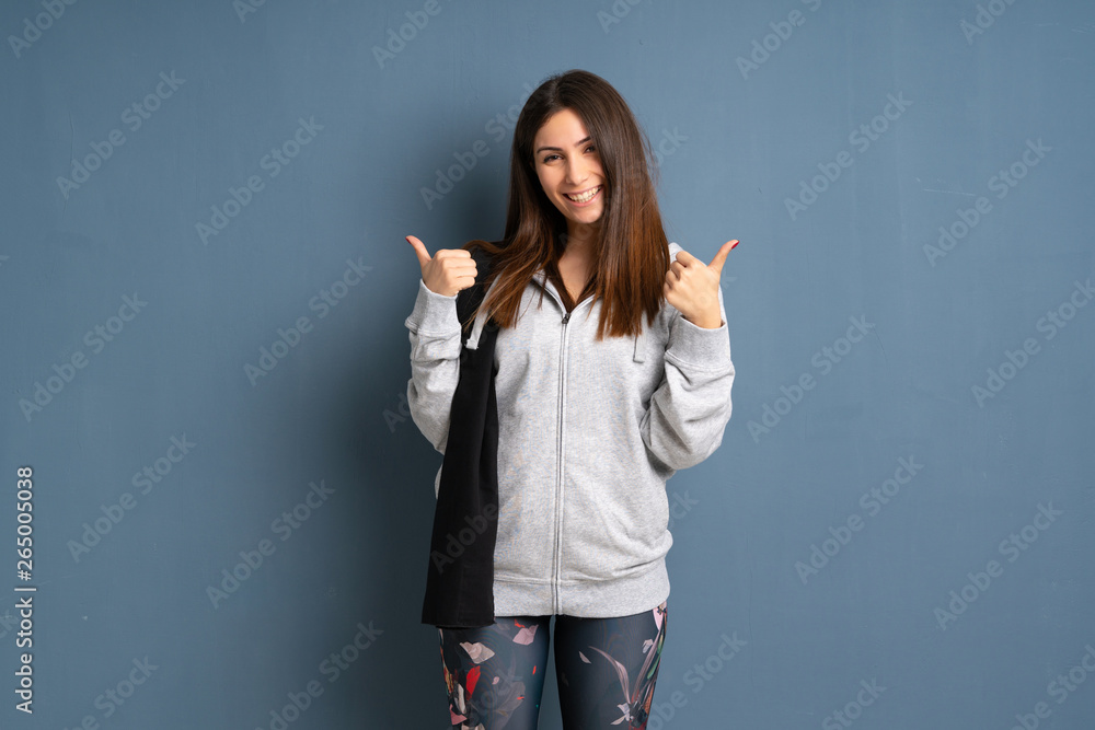 Young sport woman giving a thumbs up gesture and smiling Young sport woman giving a thumbs up gesture and smiling