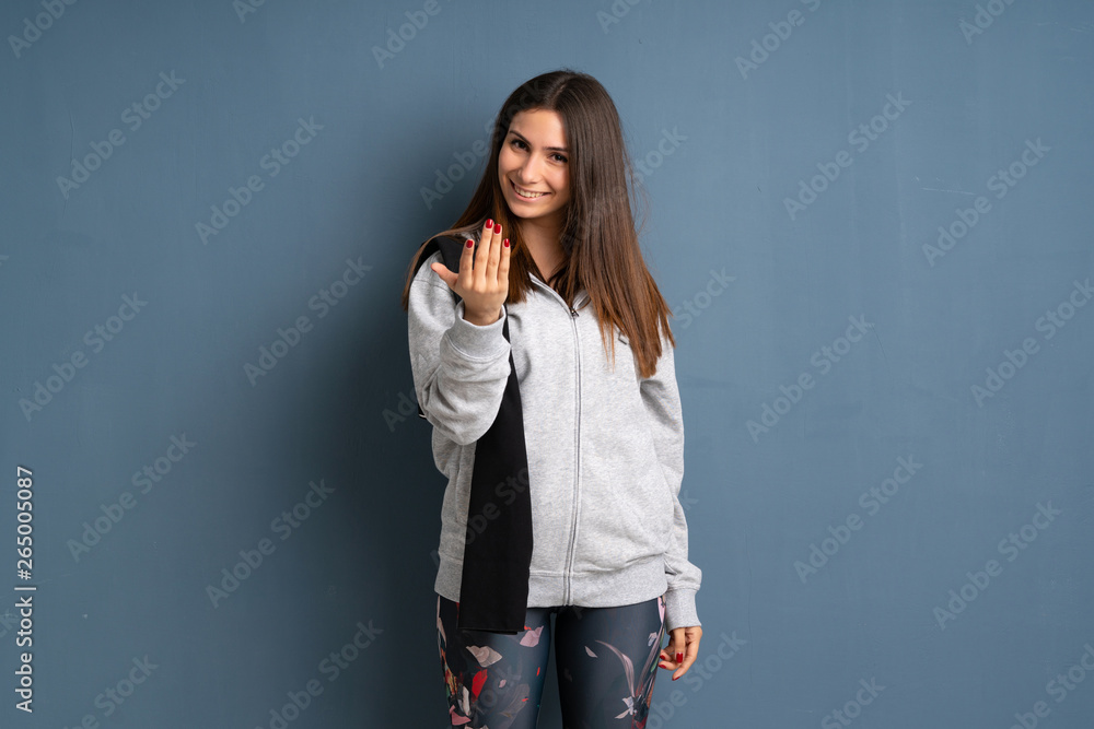 Young sport woman inviting to come with hand. Happy that you came Young sport woman inviting to come with hand. Happy that you came