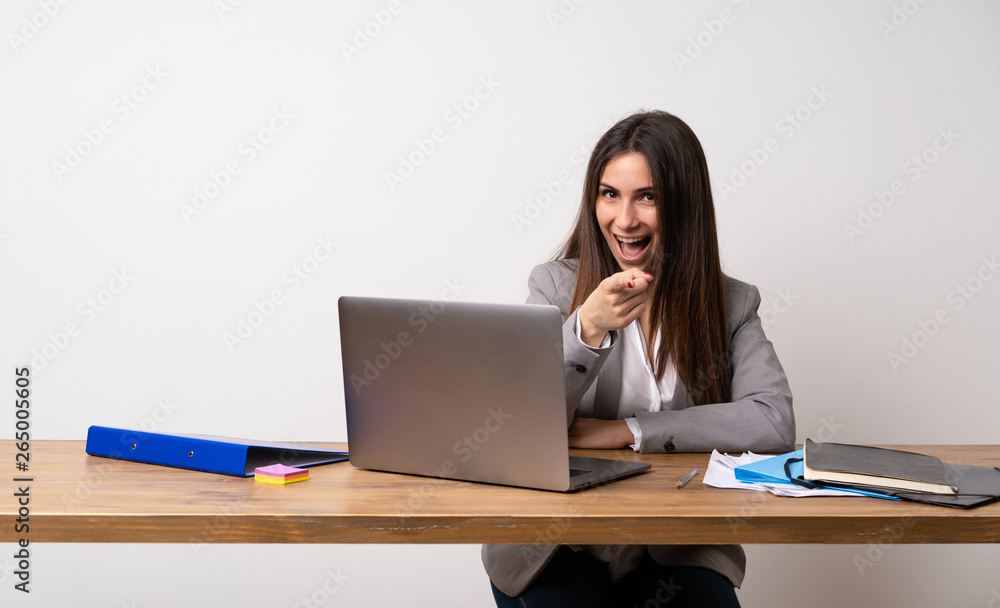 Business woman in a office surprised and pointing finger to the side Business woman in a office surprised and pointing finger to the side