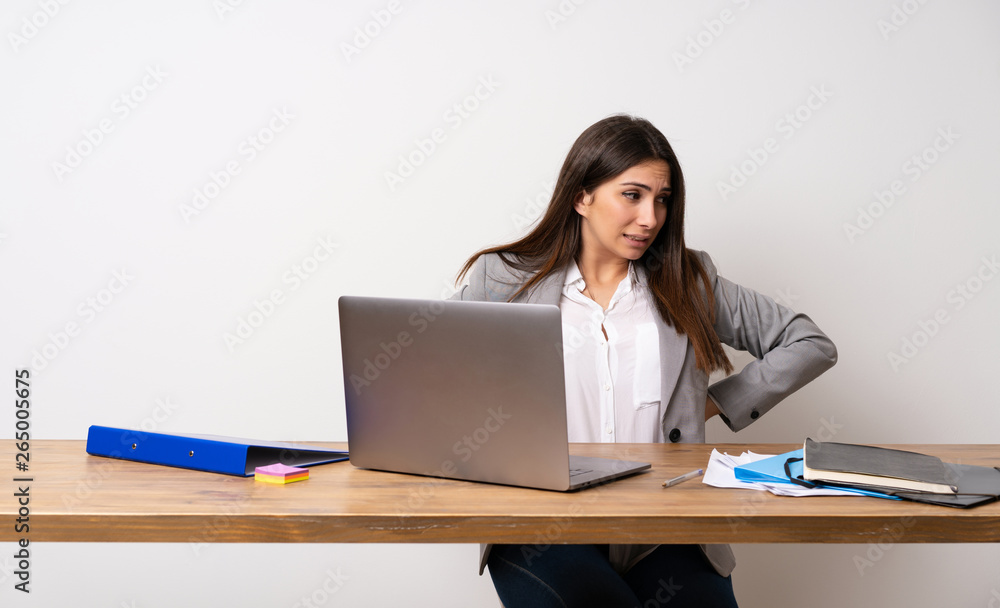 Business woman in a office suffering from backache for having made an effort Business woman in a office suffering from backache for having made an effort