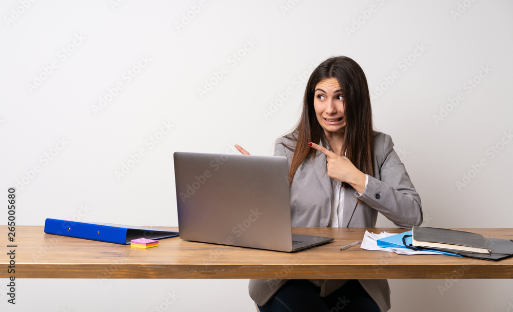 Business woman in a office frightened and pointing to the side Business woman in a office frightened and pointing to the side