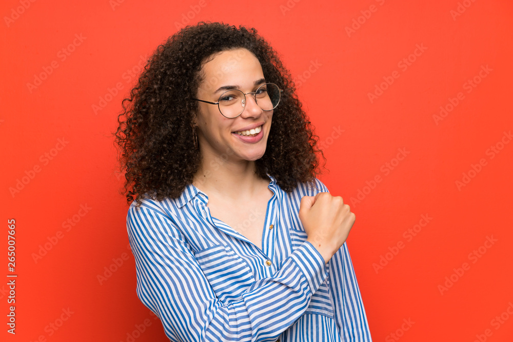 Dominican woman over red wall celebrating a victory Dominican woman over red wall celebrating a victory