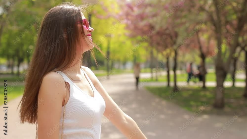 Happy woman enjoys of walk in blossom summer park Happy woman enjoys of walk in blossom summer park