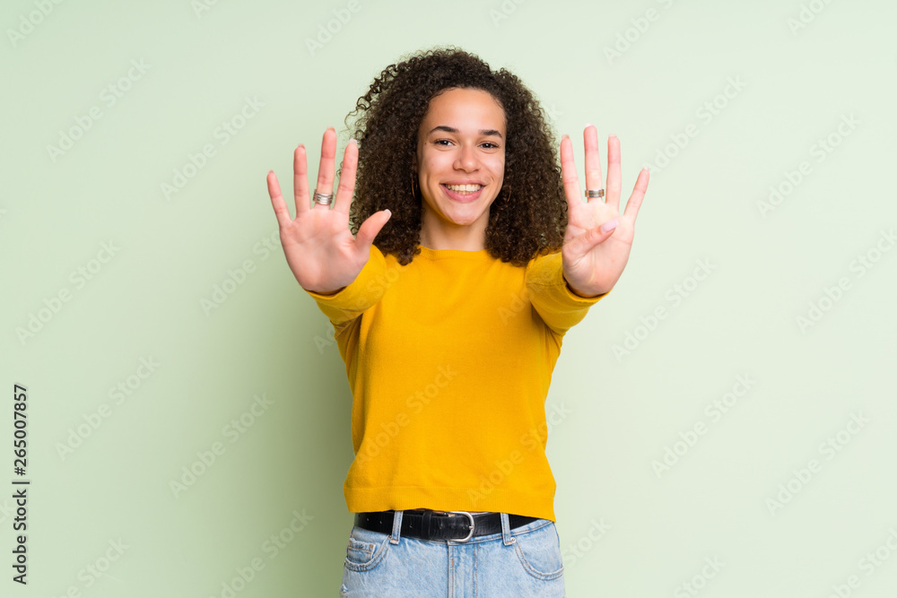 Dominican woman over isolated green background counting nine with fingers Dominican woman over isolated green background counting nine with fingers