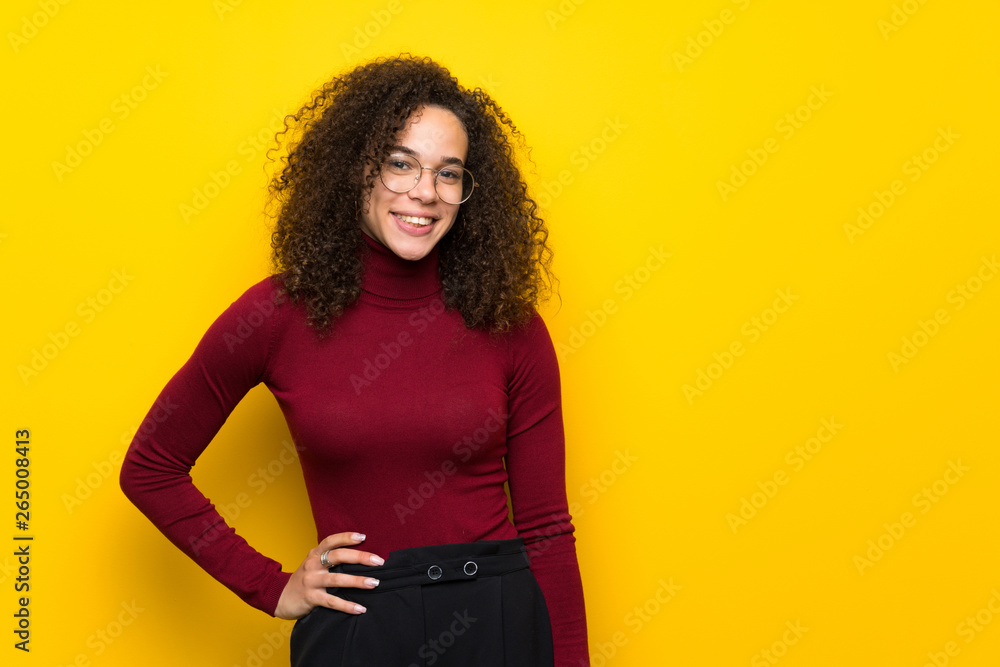 Dominican woman with turtleneck sweater posing with arms at hip and smiling Dominican woman with turtleneck sweater posing with arms at hip and smiling