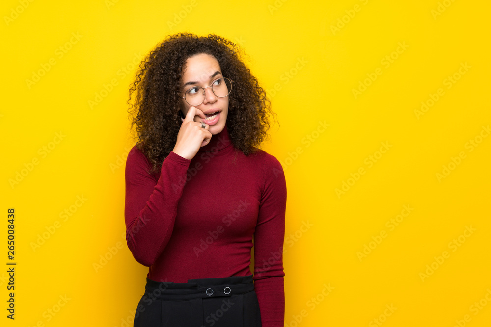 Dominican woman with turtleneck sweater having doubts while looking up Dominican woman with turtleneck sweater having doubts while looking up