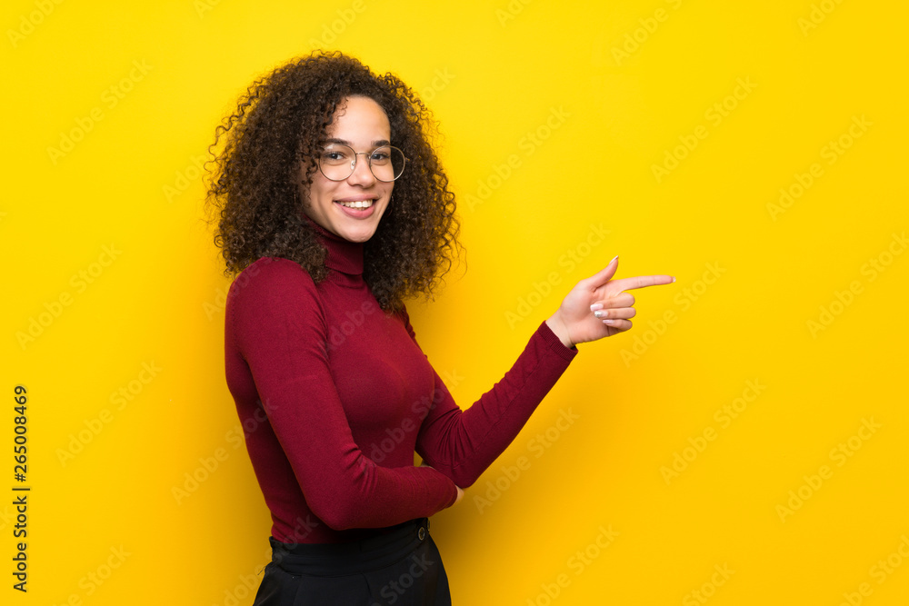 Dominican woman with turtleneck sweater pointing finger to the side in lateral position Dominican woman with turtleneck sweater pointing finger to the side in lateral position