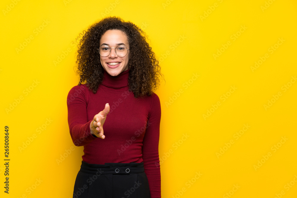 Dominican woman with turtleneck sweater shaking hands for closing a good deal Dominican woman with turtleneck sweater shaking hands for closing a good deal