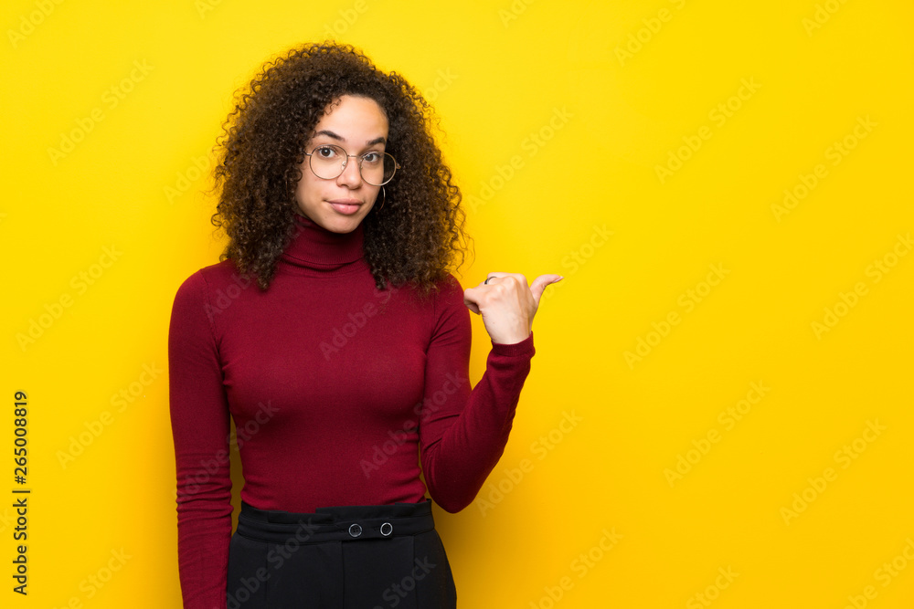 Dominican woman with turtleneck sweater pointing to the side to present a product Dominican woman with turtleneck sweater pointing to the side to present a product