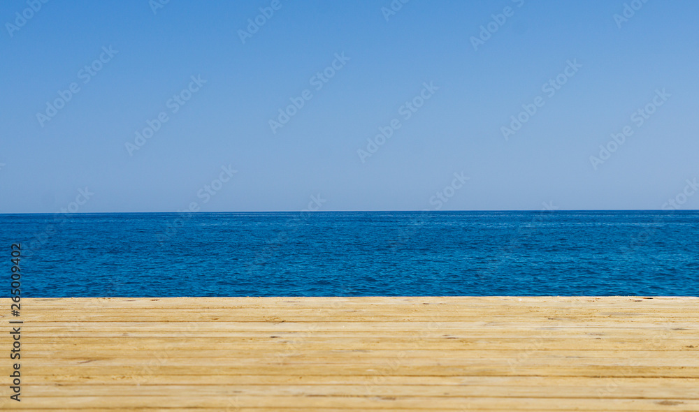 Fototapeta premium Wooden pier, sea and blue sky background. Holiday travel concept. Empty space for summer banner. Relax during vacation wallpaper