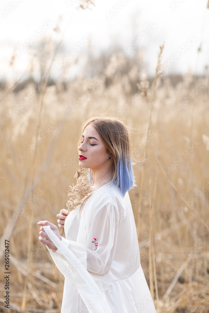 Portrait of young beautiful girl in the white dress in wheat field, walking, carefree. Enjoying the beautiful sunny day Portrait of young beautiful girl in the white dress in wheat field, walking, carefree. Enjoying the beautiful sunny day