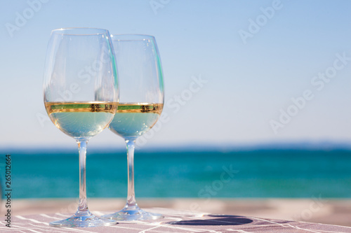 Fototapeta Naklejka Na Ścianę i Meble -  two glasses of chilled white wine on table over Garla Lake backgound