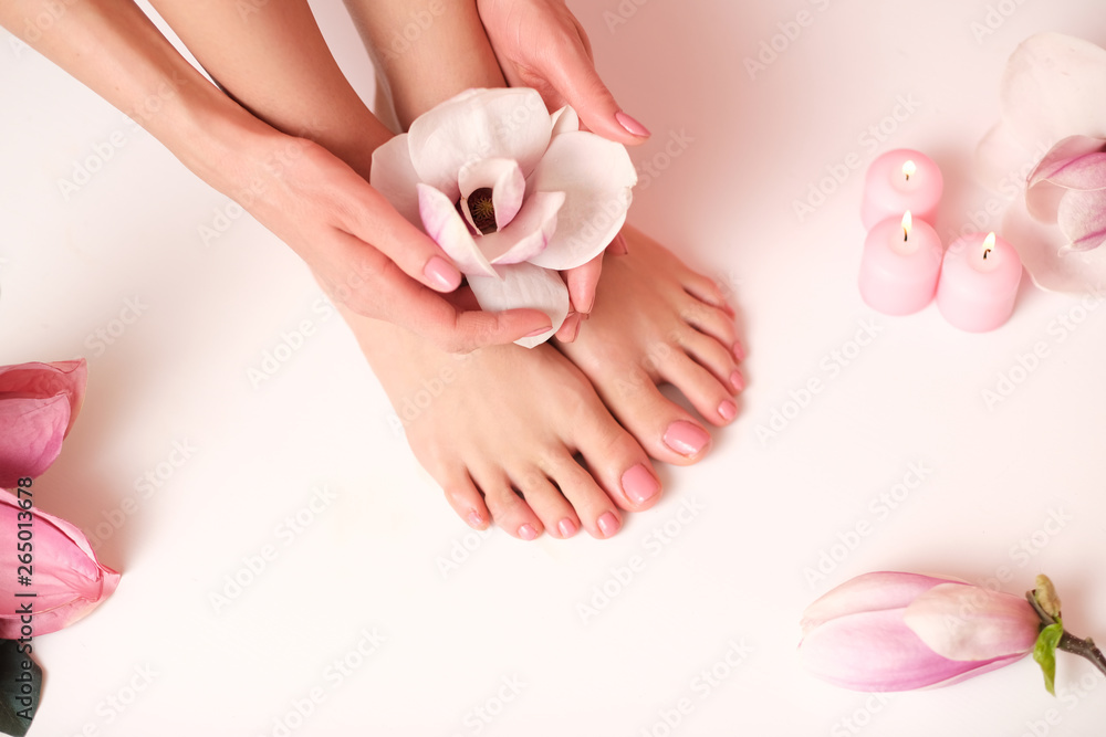 Ideal pedicure and manicure spa shoot. Female hands holding a magnolia flower. Ideal pedicure and manicure spa shoot. Female hands holding a magnolia flower.