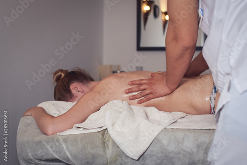 Caucasian woman receiving massage in medical salon.