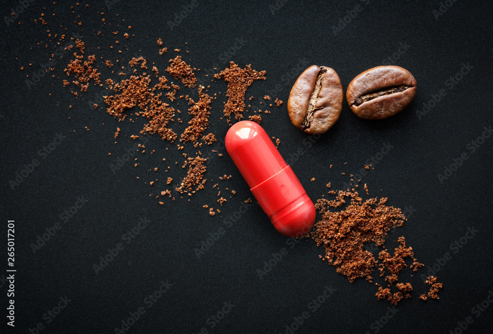 red pill and coffee beans on a black background, the concept of drugs containing caffeine - obrazy, fototapety, plakaty 