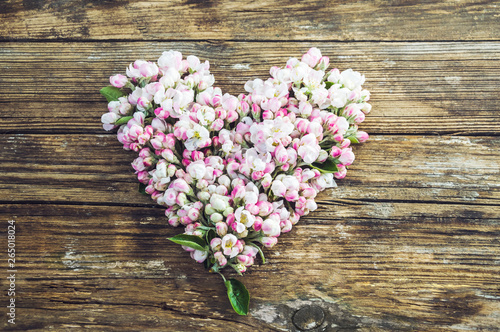 heart of flowers and buds of the apple tree. Old wooden planks background
