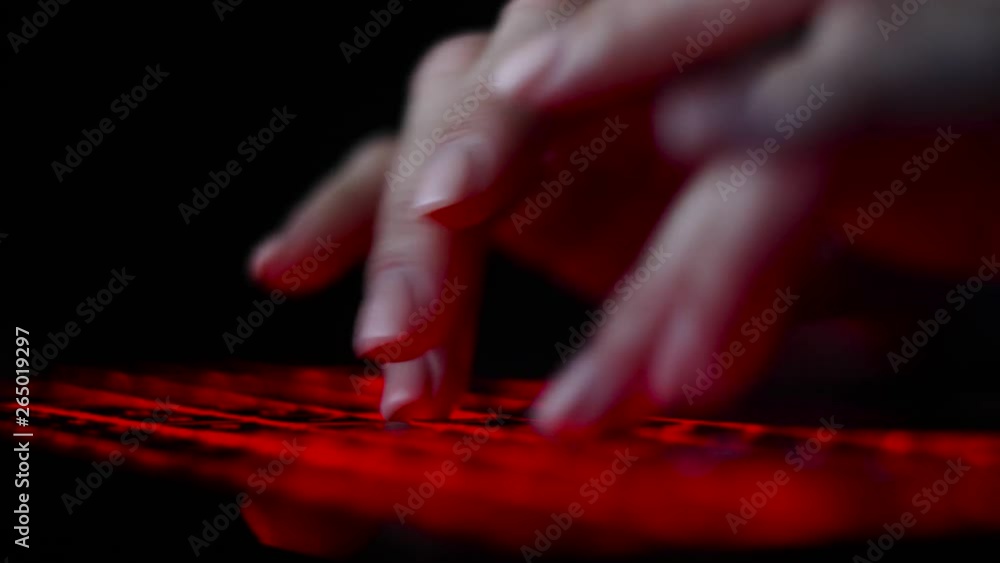 hacker girl's hand typing on keyboard with red backlight hacker girl's hand typing on keyboard with red backlight