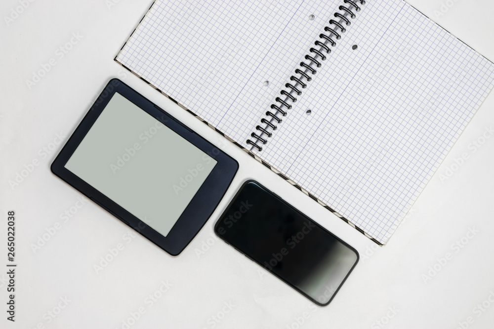 Notebook and gadgets on a white table Notebook and gadgets on a white table