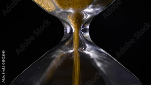 Golden sand falling from the hourglass