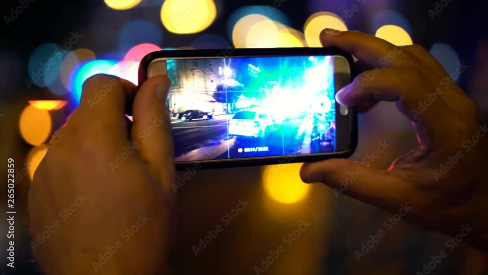 Man recording accident place on smartphone in the night Man recording accident place on smartphone in the night