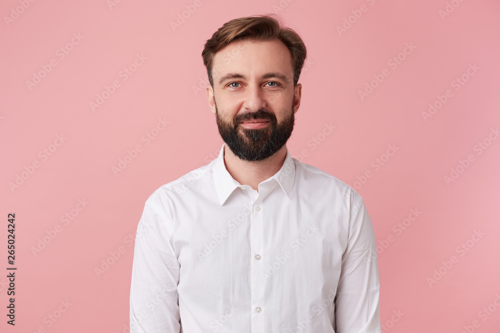 Fotografie Portrait of young calm smiling handsome bearded man, wearing a white shirt