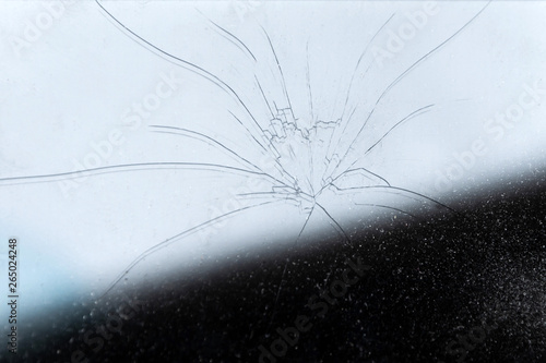 background: phone glass covered with concentric cracks, dust particles, toning, partial shade © BUSLIQ
