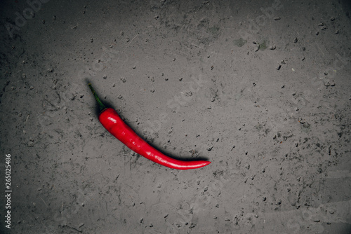 Red hot chilli pepper on a stone countertop. Chilli pepper ready to cook. Peppers lie on a countertop, the concept of cooking and preparing a meal.