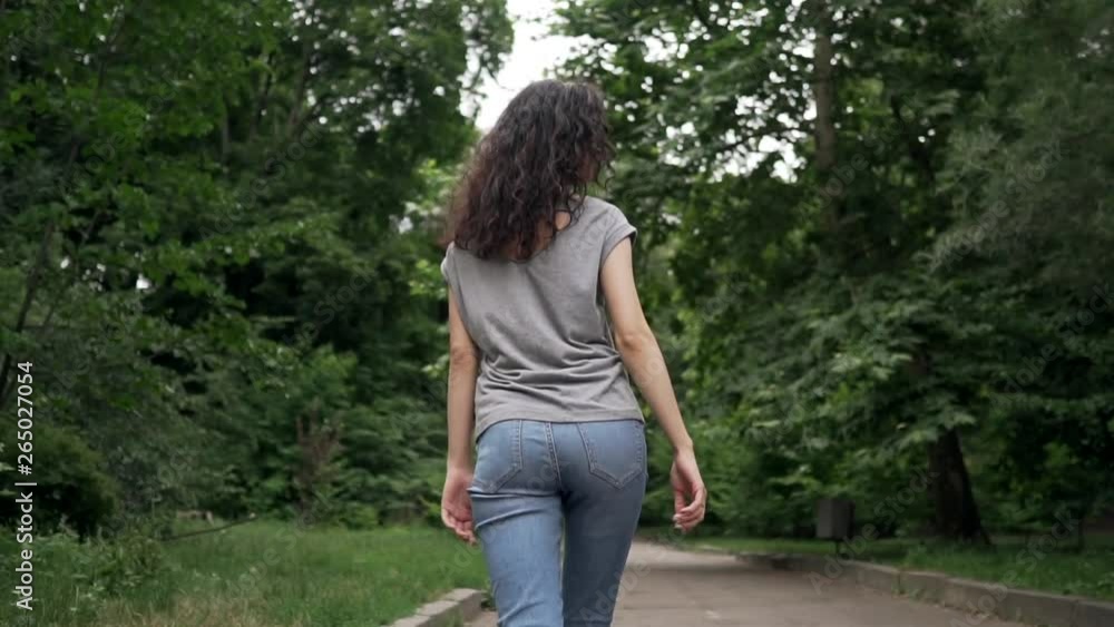 young beautiful curly brunette female smiling and walking young beautiful curly brunette female smiling and walking