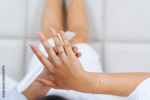 Male hand holds the female palm on light background.