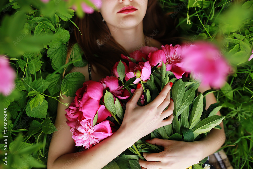 Bouquet of Peony. Stylish fashion photo of beautiful young woman lies among peonies. Holidays and Events. Valentine's Day. Spring blossom. Summer season