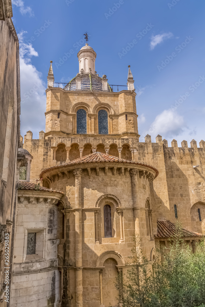 View of lateral facade and cupola of the gothic building of Coimbra Cathedral, Coimbra city and sky as background