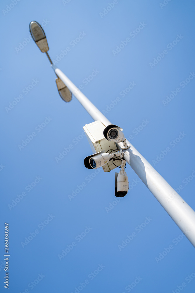 Surveillance camera on a pole against the sky Surveillance camera on a pole against the sky