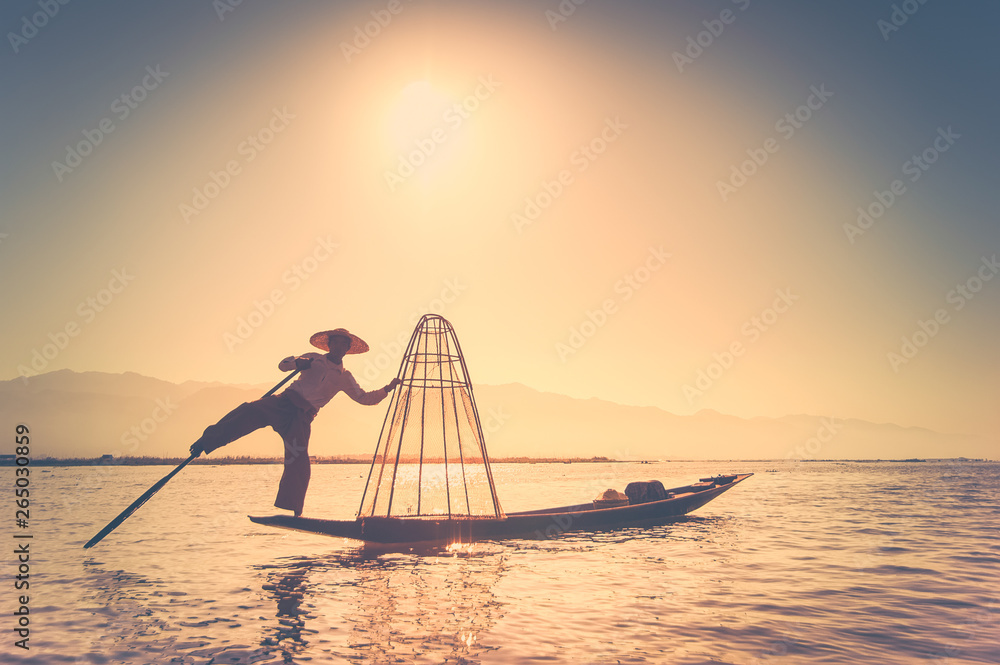 Burmese fisherman catching fish in traditional way. Inle lake, Myanmar