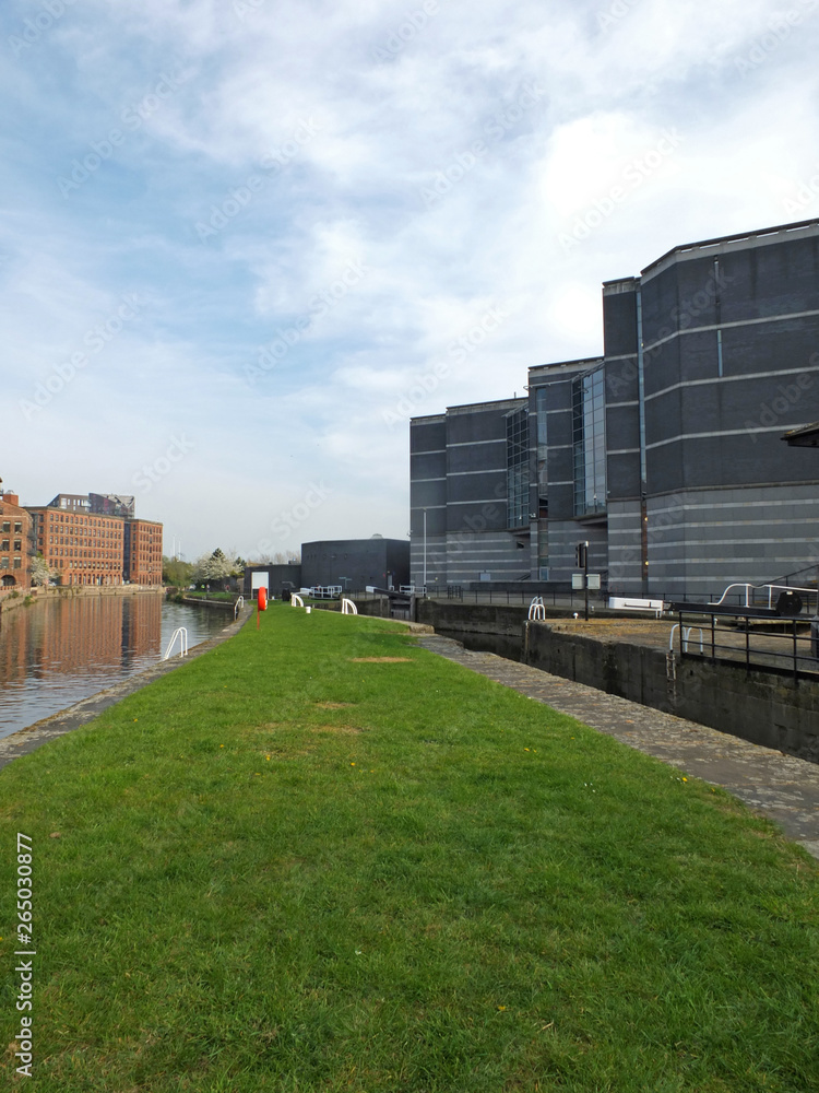 the leeds lock entrance to clarence dock with footbridge over the river aire and lock gates and mooring area surrounded by modern apartment developments and knight bridge