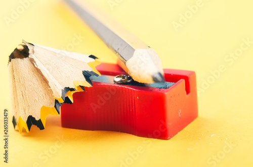 Back To school Concept, pencil with it shavings and sharpener over yellow background