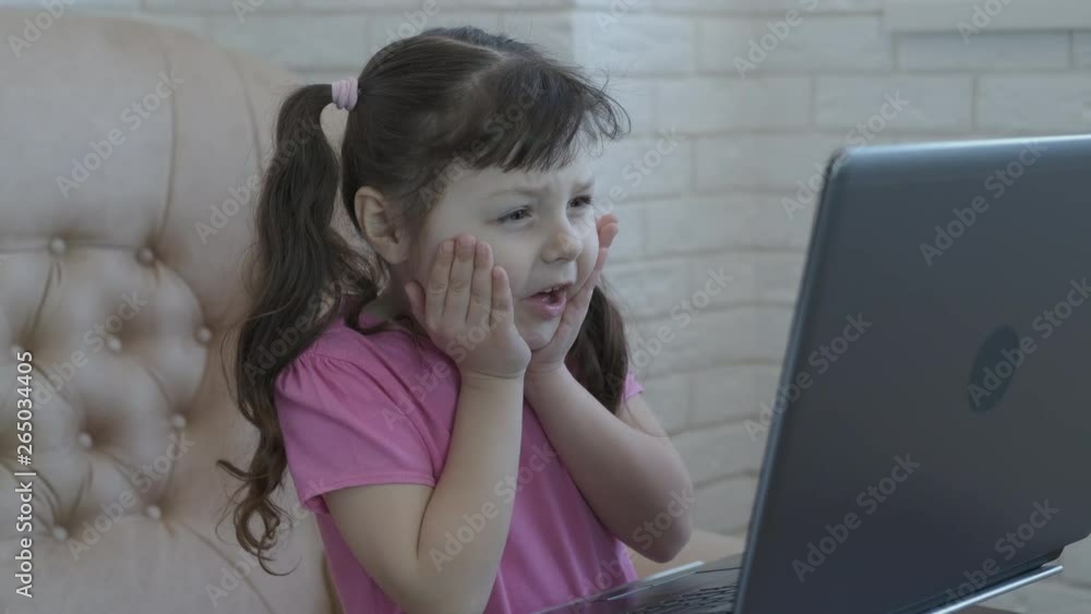 Scare the child on the Internet. The little girl is shocked by what he ...