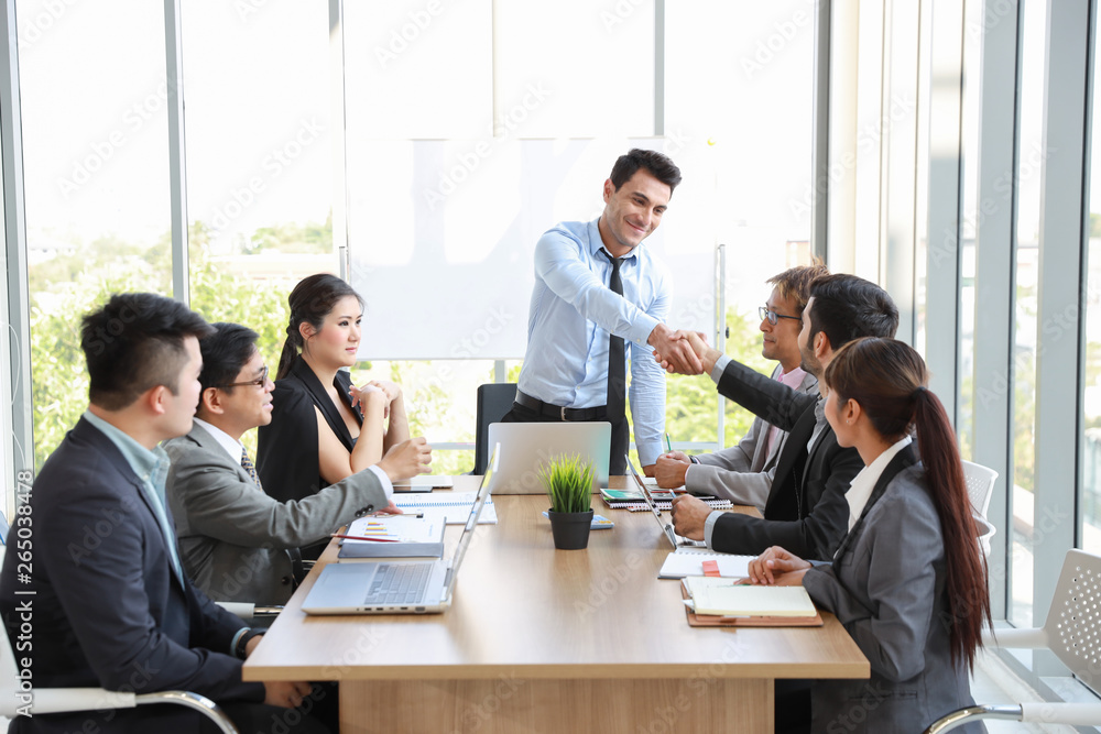 caucasian businessman showing success business profit graph from white board in meeting then they shaking their hands meaning of their job is success with smiling and happy faces. caucasian businessman showing success business profit graph from white board in meeting then they shaking their hands meaning of their job is success with smiling and happy faces.