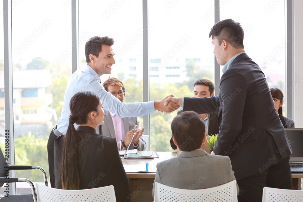 caucasian businessman showing success business profit graph from white board in meeting then they shaking their hands meaning of their job is success with smiling and happy faces.